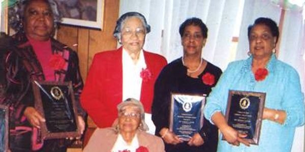 Five women holding award plaques